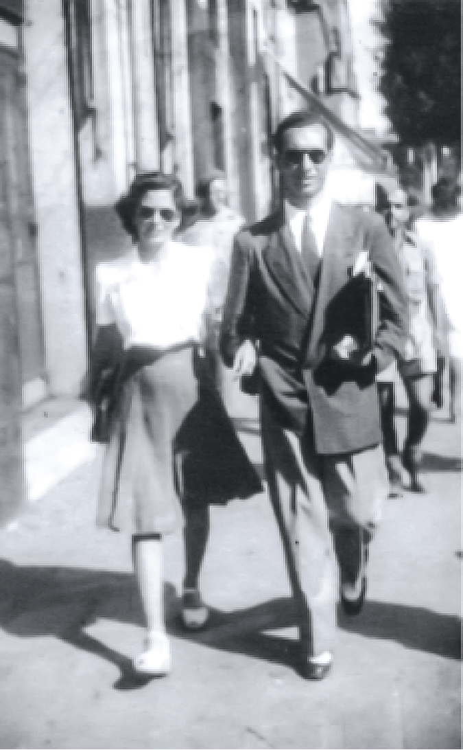 Foto d'epoca in bianco e nero: una coppia elegante cammina lungo una strada cittadina